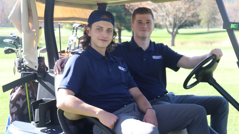 Thomas Portnoy ’25 (right) at a golf outing with the Gaia Initiative.