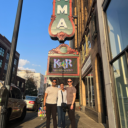 The team poses for a photo in front of a marquee.