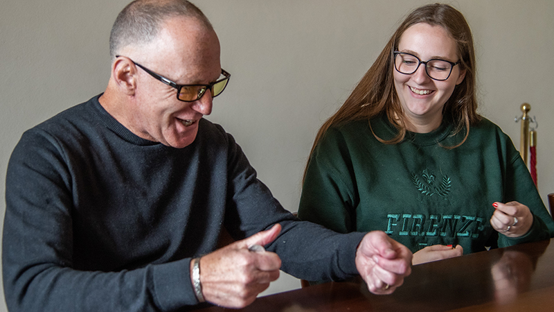 Dr. Morgan helps Emily Kelliher ’24 perfect her magic trick.