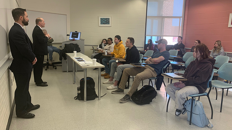 U.S. Secret Service recruiters, including Prof. Justin Hanson (left) speak to students in Prof. Kenneth Gray’s class.