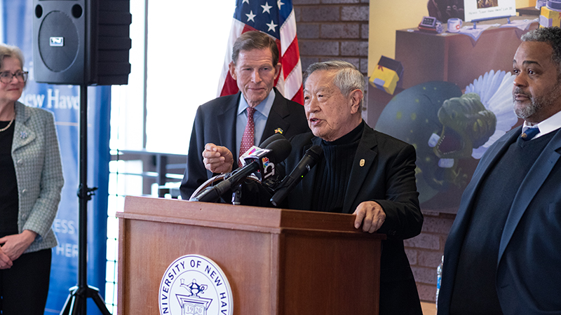 Dr. Henry Lee speaks at a podium.