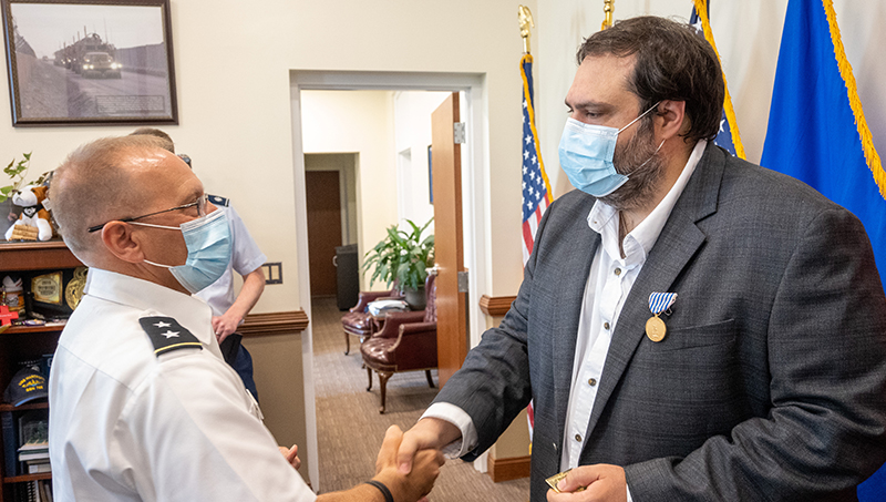 Ibrahim Baggili shaking hands with a service member.