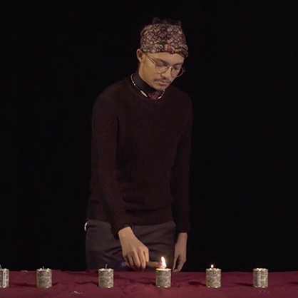 A student lights six candles on a table