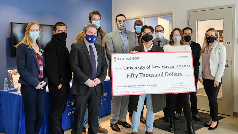 Francis Escolin ’22 (center) poses with University staff and faculty.