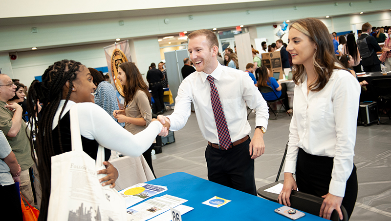 Employer shaking hands with student.